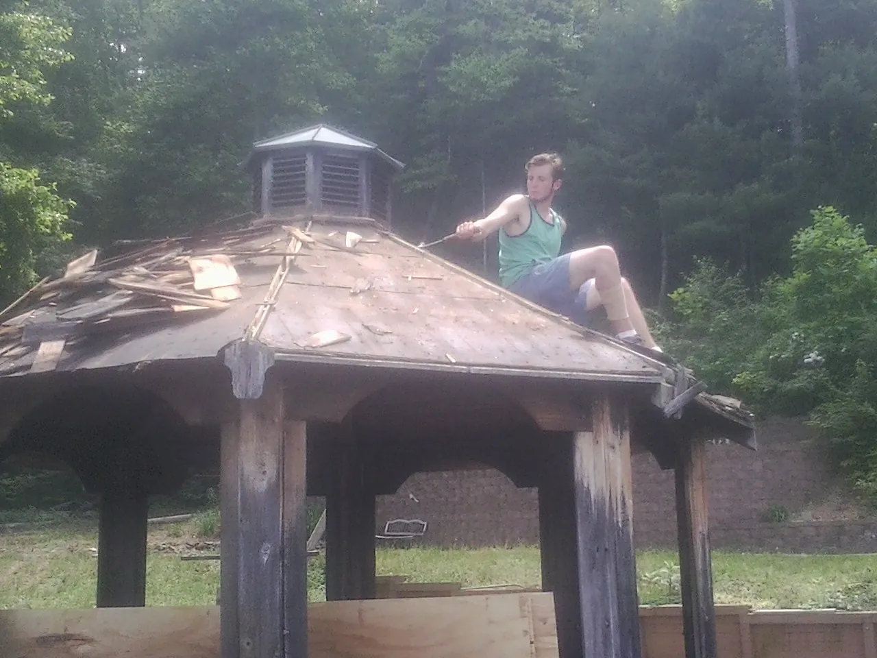 Tearing the old roof off a wooden gazebo before new shakes in Long Beach